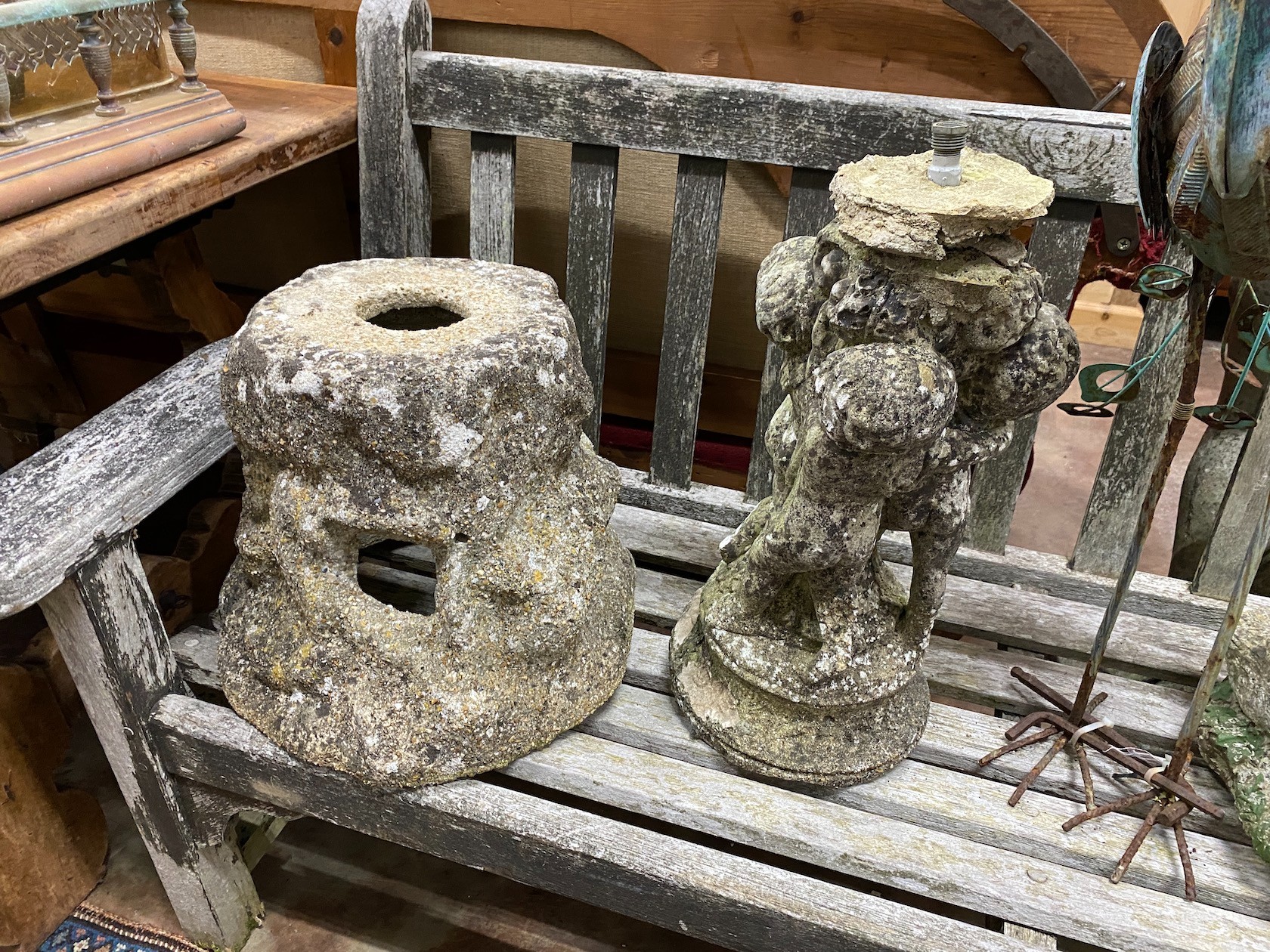 A group of four reconstituted stone garden ornaments and a painted metal peacock
